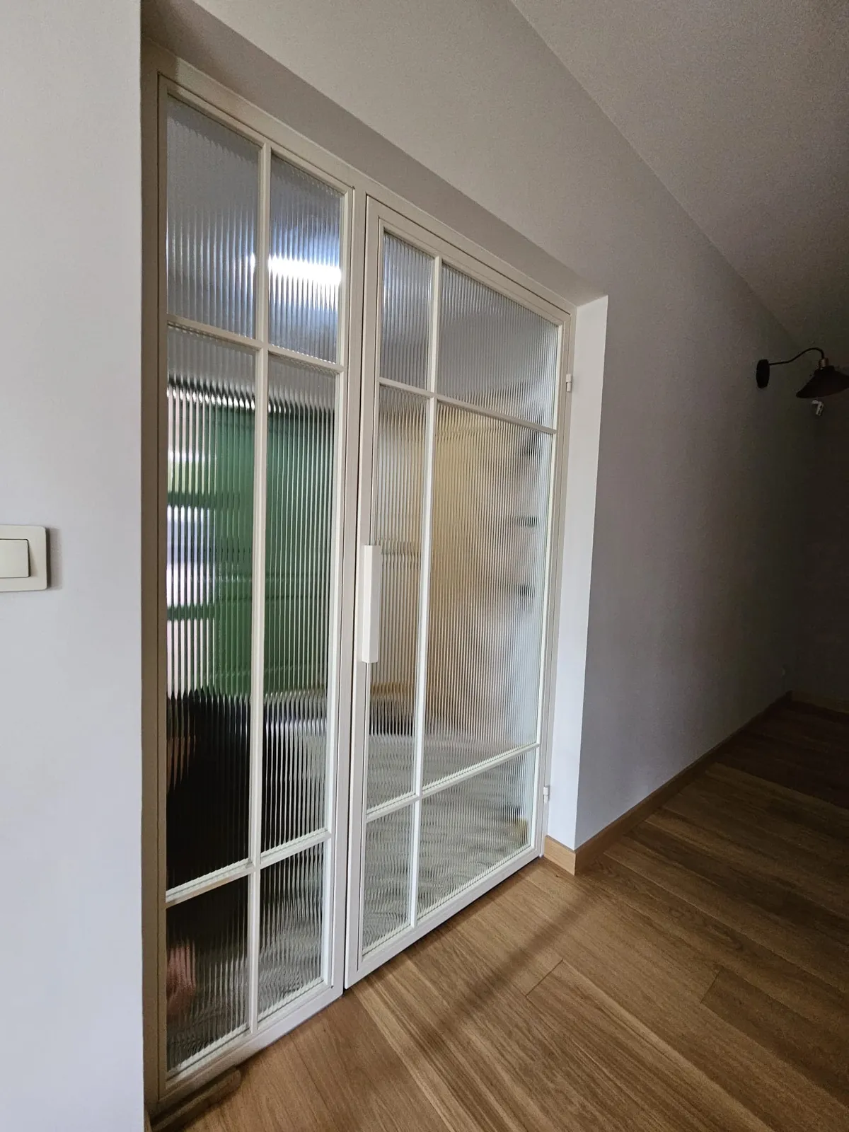 Przesuwne drzwi szklane z ryflowanego szkła w jasnej ramie typu loft