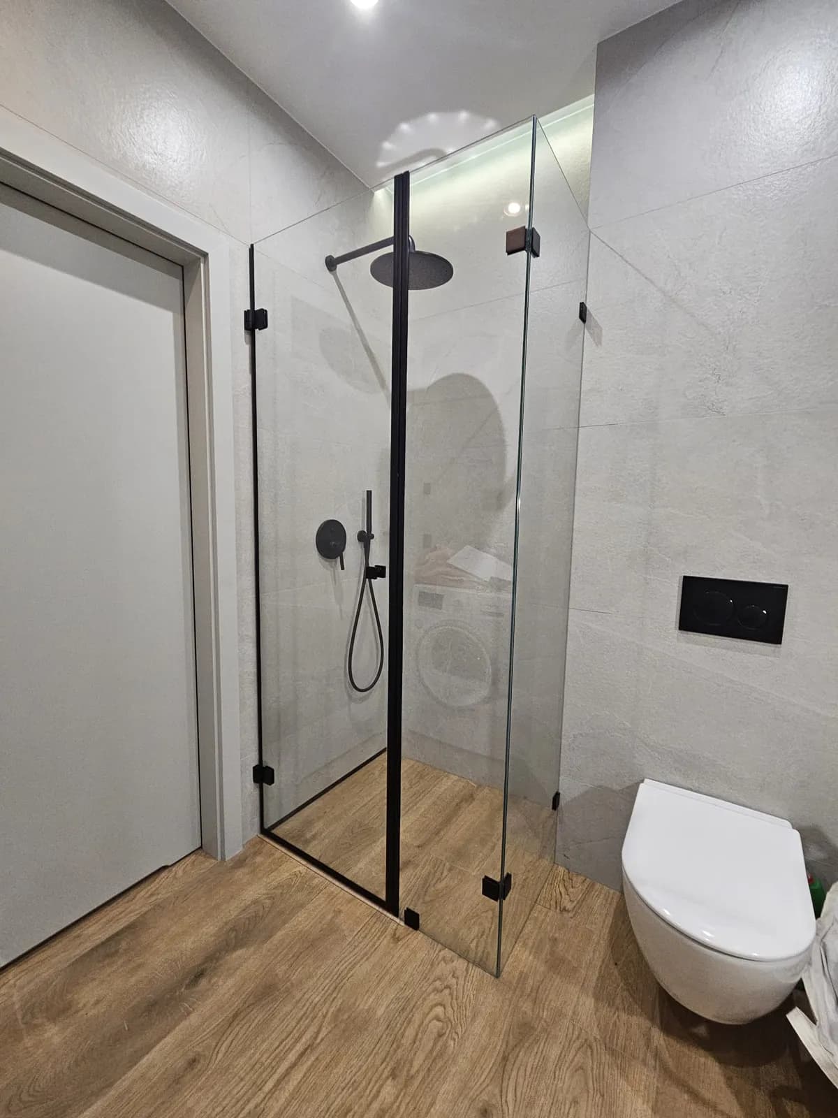 Bezramowa kabina prysznicowa walk-in z czarnymi profilami w jasnej łazience