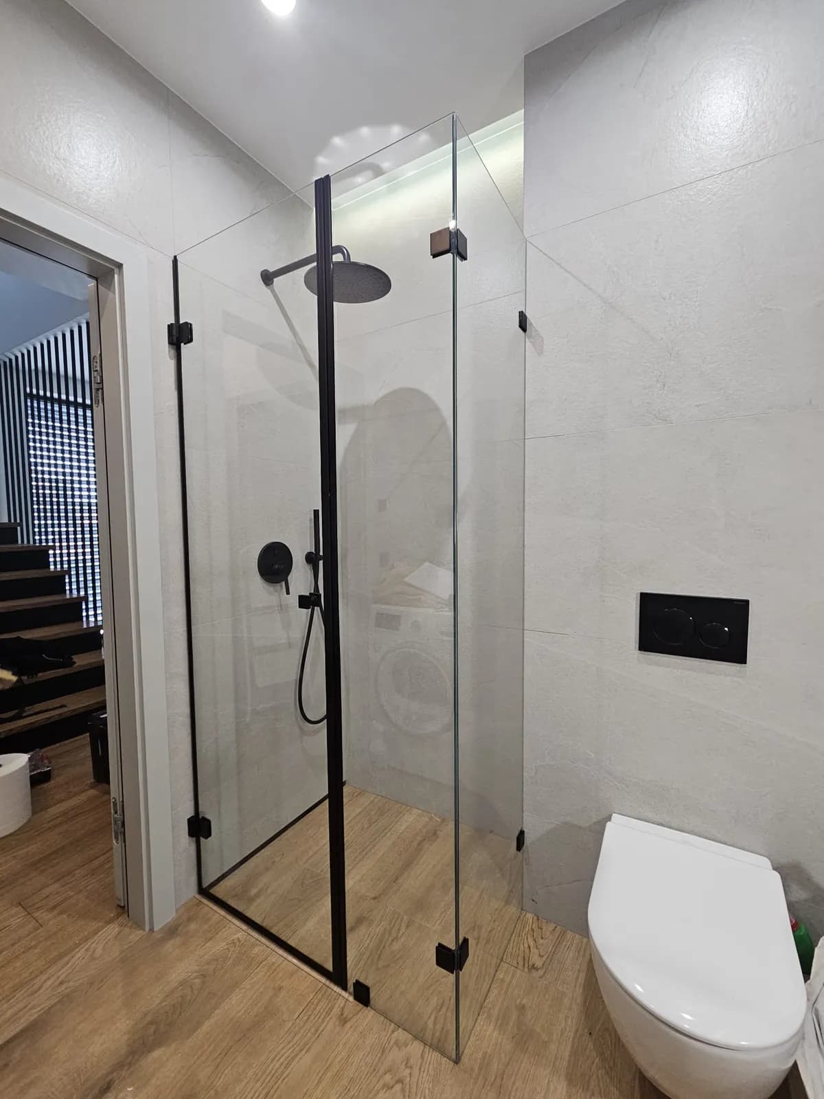 Szklana kabina prysznicowa walk-in z czarnym profilem i deszczownicą
