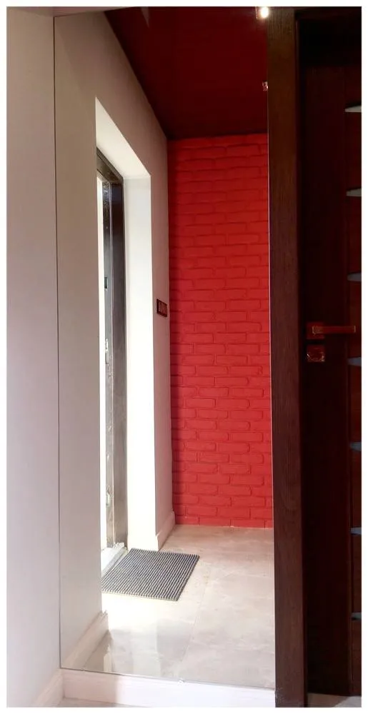 Lustro w przedpokoju z ceglaną ścianą